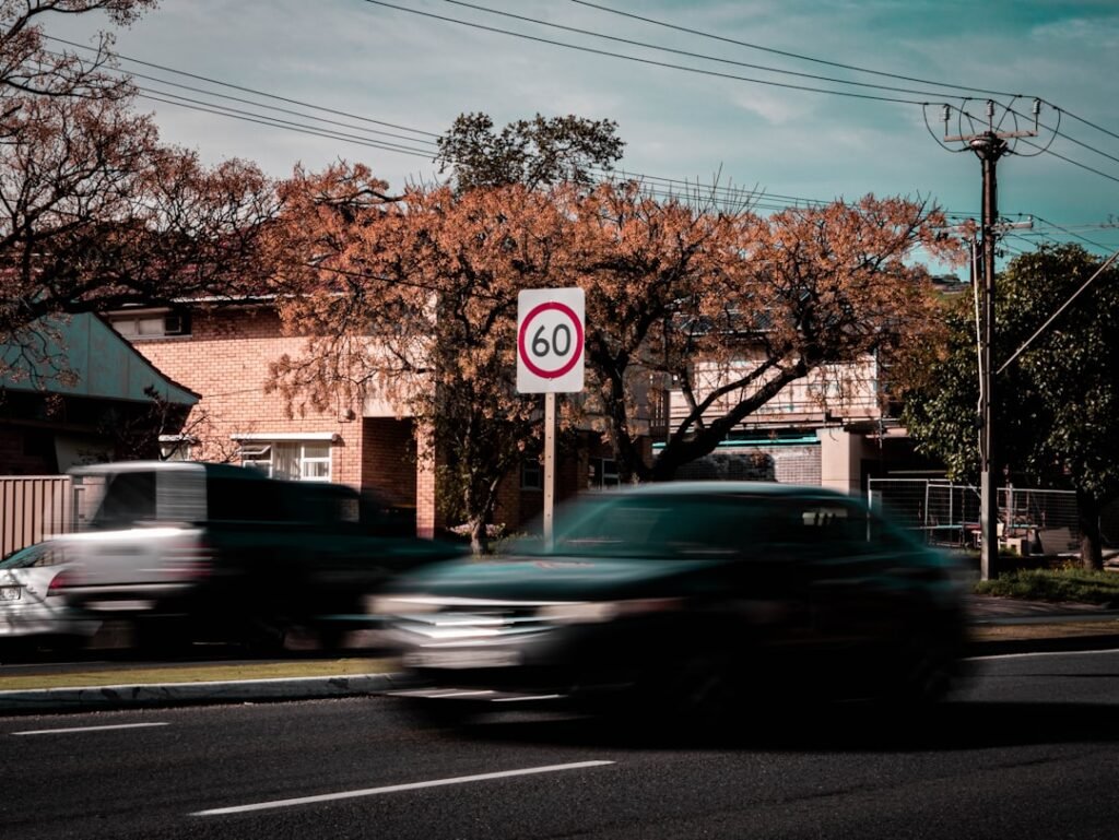 car driving on road beside a speed limit sign