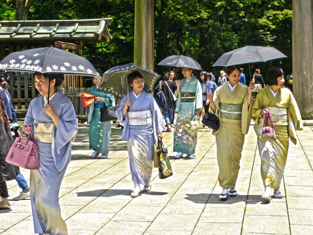 womans walking holding umbrella